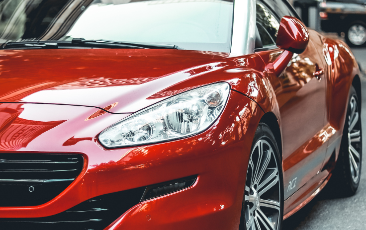 A red car with ceramic coating is parked outside